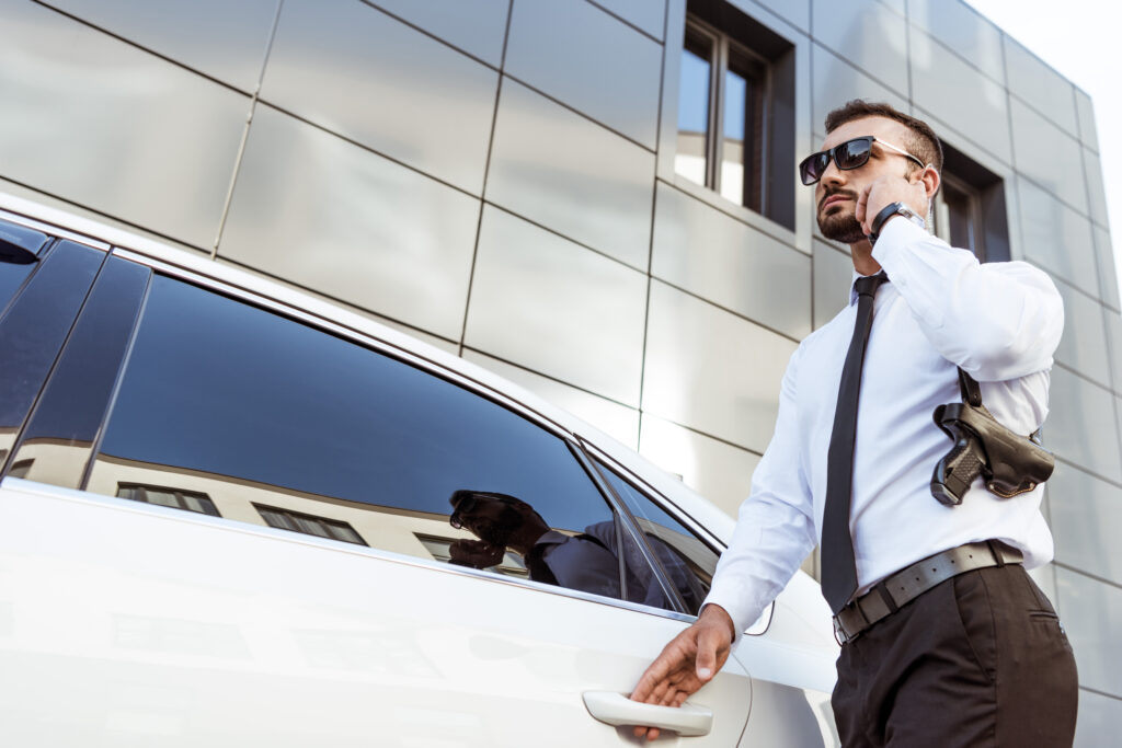 A man in sunglasses and a tie is talking on the phone.